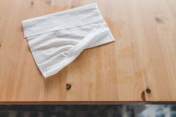 hand cleaning woooden coffee table with disinfectant wet wipe concept of the new normal after covid-19