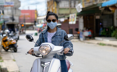 Woman riding a motorcycle wearing a mask in the city