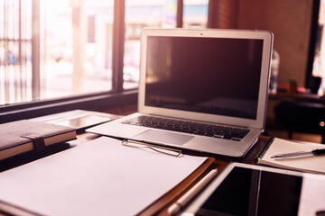 Office workplace with laptop, calculator, book and document on wood table