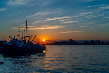 Obraz premium Seascape with a ship on the background of the sunset.