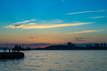 Obraz premium Seascape with a silhouette of people on the pier.