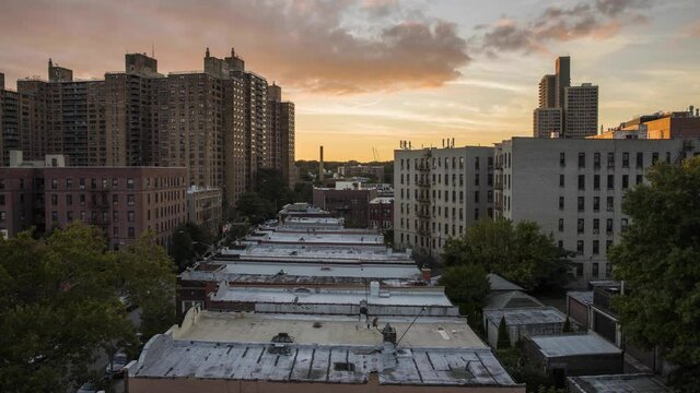 Sun sets over Brooklyn while neighborhood bustles around below, time lapse