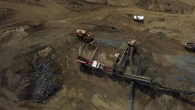 Loader on construction site dumps large rocks into processing equipment on a construction site in Southern California