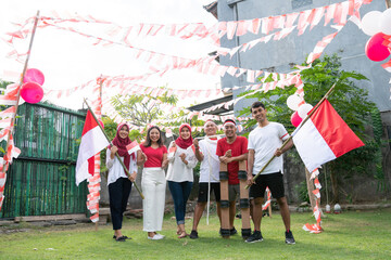 group of young people in red and white clothes carrying Indonesian attributes and flags