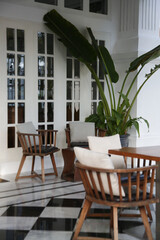 Stylish restaurant with black and white ceramic tiles floor and wooden furniture, no people