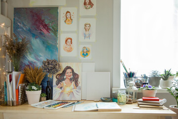 An illustrator's workplace. Brushes, paints, sketchbooks and blank canvases.
