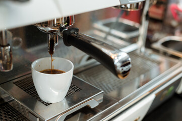 black coffee in white cup put on coffee maker