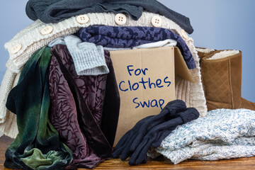 Preloved clothes in a box marked for Clothes Swap, reuse recycle clothes by swapping for...
