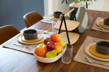 Modern Scandinavian dinning table and plate setting with apple fruit on plate.