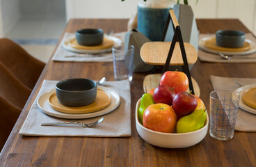 Modern Scandinavian dinning table and plate setting with apple fruit on plate.