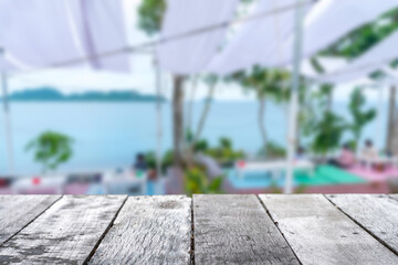 Selective focus of wooden table with blur coffee and restutant cafe with customers.