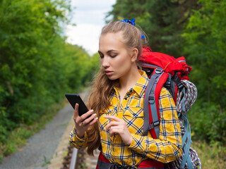 Hiker woman lost in forest. She using mobile GPS map.