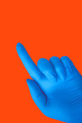 Hand in blue medical glove isolated on orange with gesture. Protection concept