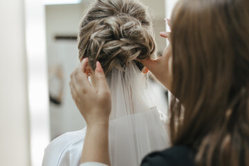 The barber makes hairstyle for bride. The fees of the bride