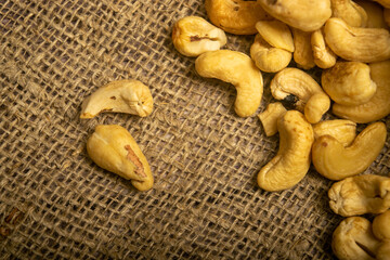 A pile of cashew nuts on burlap with a rough texture surface texture. Close up.