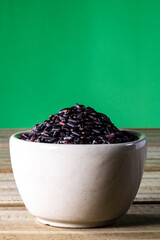 Fototapeta na wymiar black venus rice on glass bowl isolated on wooden table in Brazil