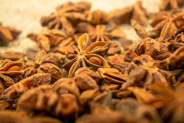 A pile of star anise on a background of burlap with a rough texture surface texture. Close up.