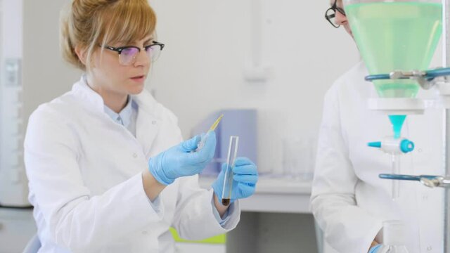 Chemist working with hemp CBD oil and tablet in laboratory