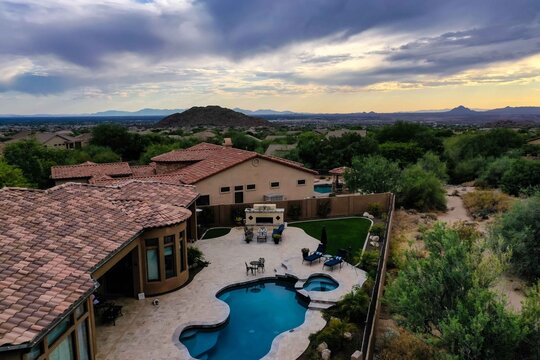 A high definition aerial view of a a home in Arizona with dramatic landscaping during sunset.