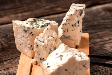 Tasty blue cheese on a wooden background. Dorblu cheese pieces, Danish blue cheese