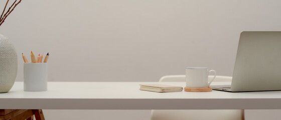 Simple worktable with laptop, supplies, decoration and copy space in home office