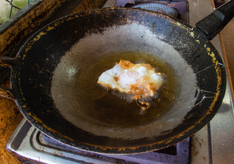 Fried egg in a pan,thai style fried egg,fried egg in hot oil,crispy fried egg