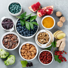 Various superfoods on grey background.