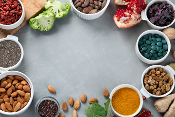 Various superfoods on grey background.