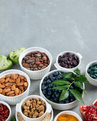 Various superfoods on grey background.