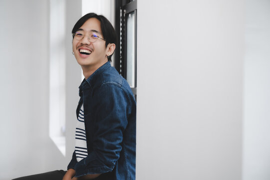 Young Hipster Happy Asian Man Smile And Sitting  Side Window