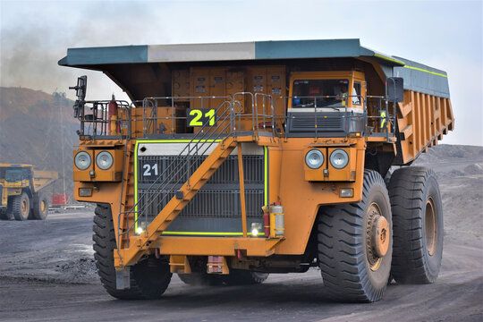 Huge Dumper Earthmover Truck carrying minerals at an open pit quarry mines.