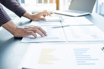 The hands of a male businessman are analyzing and calculating the annual income and expenses in a...