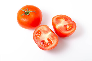 Two red tomatoes are seen tail green on a white background front and top view. One tomato is whole,...