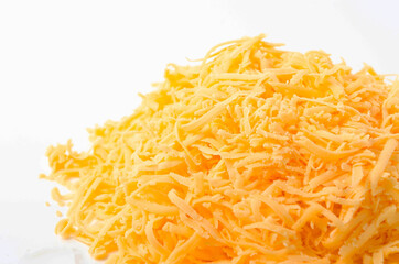 Grated hard cheese on a white plate. Russian cheese, Dutch, parmesan heap grated on a white plate in a close-up top and top view