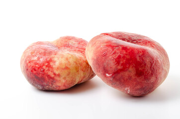 Two bright, juicy peaches on a white background. Fig peach in close-up on a white background one on one. Water drops on a peach, dew in close-up