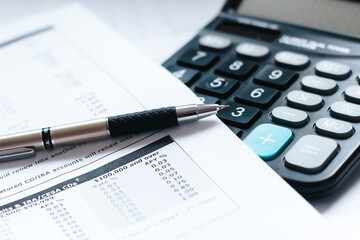 calculator and pen on financial documents