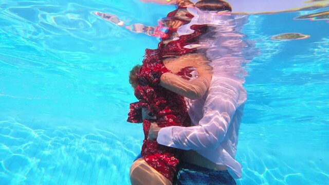 underwater shot of young couple embrace kissing in the pool
