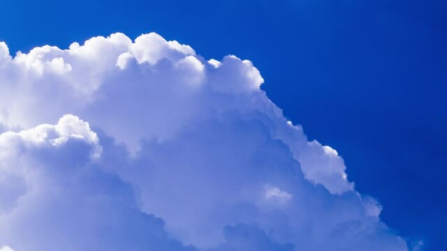 Fluffy clouds silver lining on vivid polarised blue sky background, copy space.