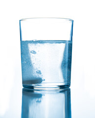 a glass of water with a soluble tablet inside