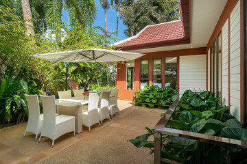 Exterior design of house, home and villa feature terrace, outdoor table, chair, umbrella and garden