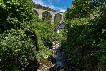 Spectacular view of an old house in front of the old railway bridge at the Ravenna gorge viaduct in...