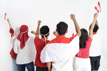 group of people celebrating indonesia national day holding flag shoot from behind with copy space