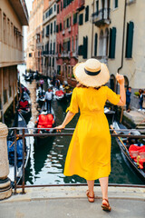 woman in yellow sundress at bridge with view at venice canal