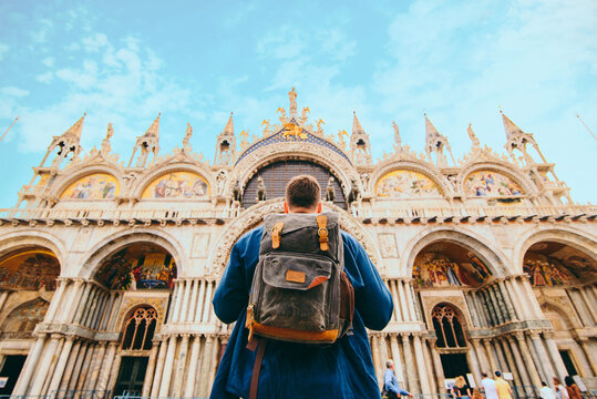 tourist man with backpack standing in front of saint marco basilica Venice, Italy