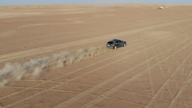 Race car is driving in the sand desert. Dubai, aerial drone camera shooting