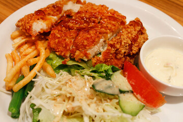 Deep fried chicken in a sweet vinegar sauce with the salad and french fries in Kyoto, Japan
