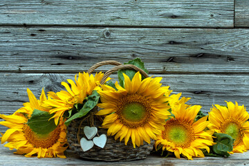 Sonnenblumen mit Blumenstrauss vor Holz