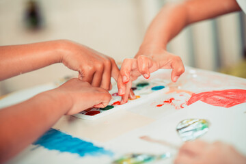Obraz premium Kids painting with watercolors using their fingers