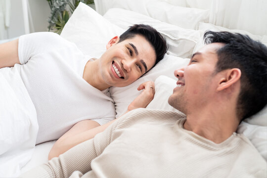 LGBT, smile Asian gay lover homosexual couple lying on bed together.