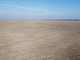Naklejka premium Agricultural fields on a sunny spring day, aerial view. Landscape. Blue sky over the fields.